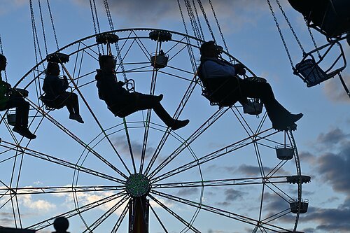 Kettenkarussell und Riesenrad Kettenkarussell und Riesenrad im Hintergrund in der Dämmerung